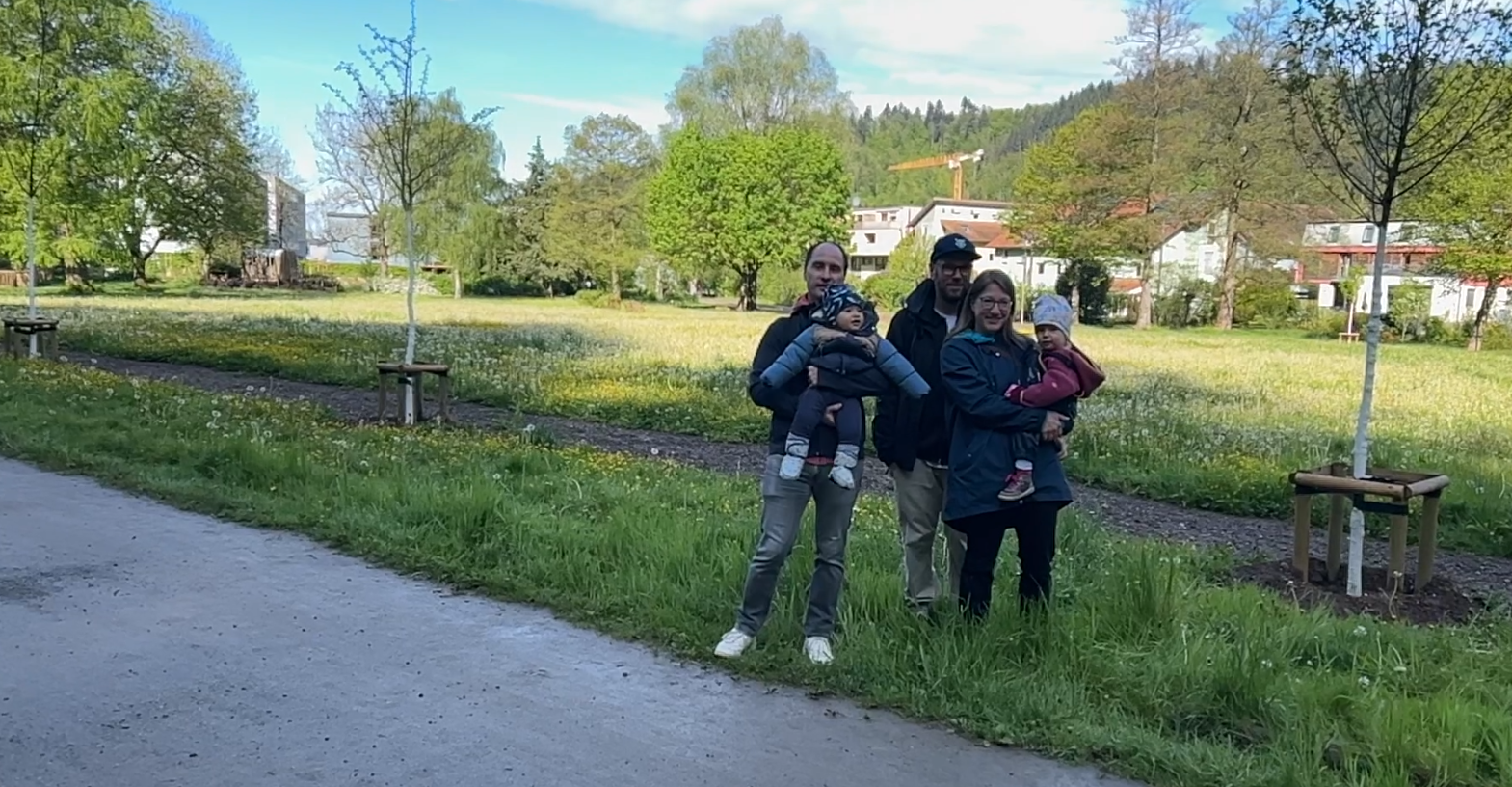 Zwei Familien mit Kindern neben jungen Bäumen